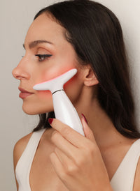 Συσκευή LED αντιγήρανσης προσώπου σε χρήση στο μάγουλο για σύσφιξη, τόνωση και λείανση ρυτίδων